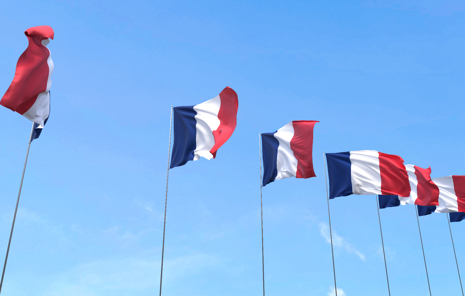 Des drapeaux français qui flottent au vent avec un ciel bleu en arrière-plan