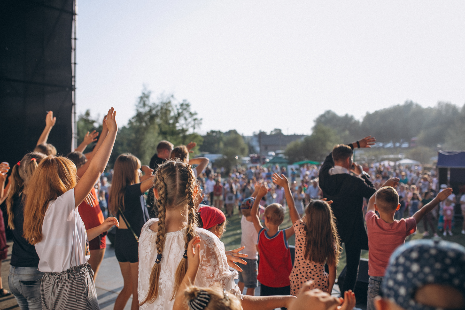 Des personnes de dos assistant à un concert en plein air