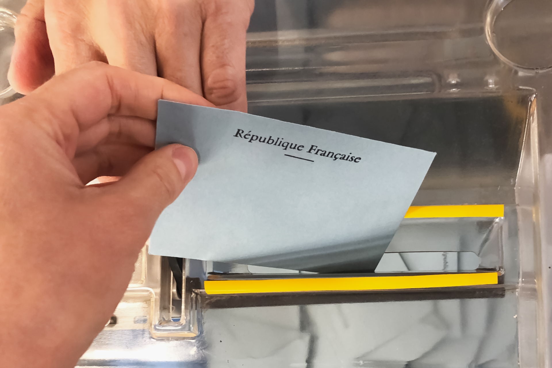 Une main déposant une enveloppe dans l'urne